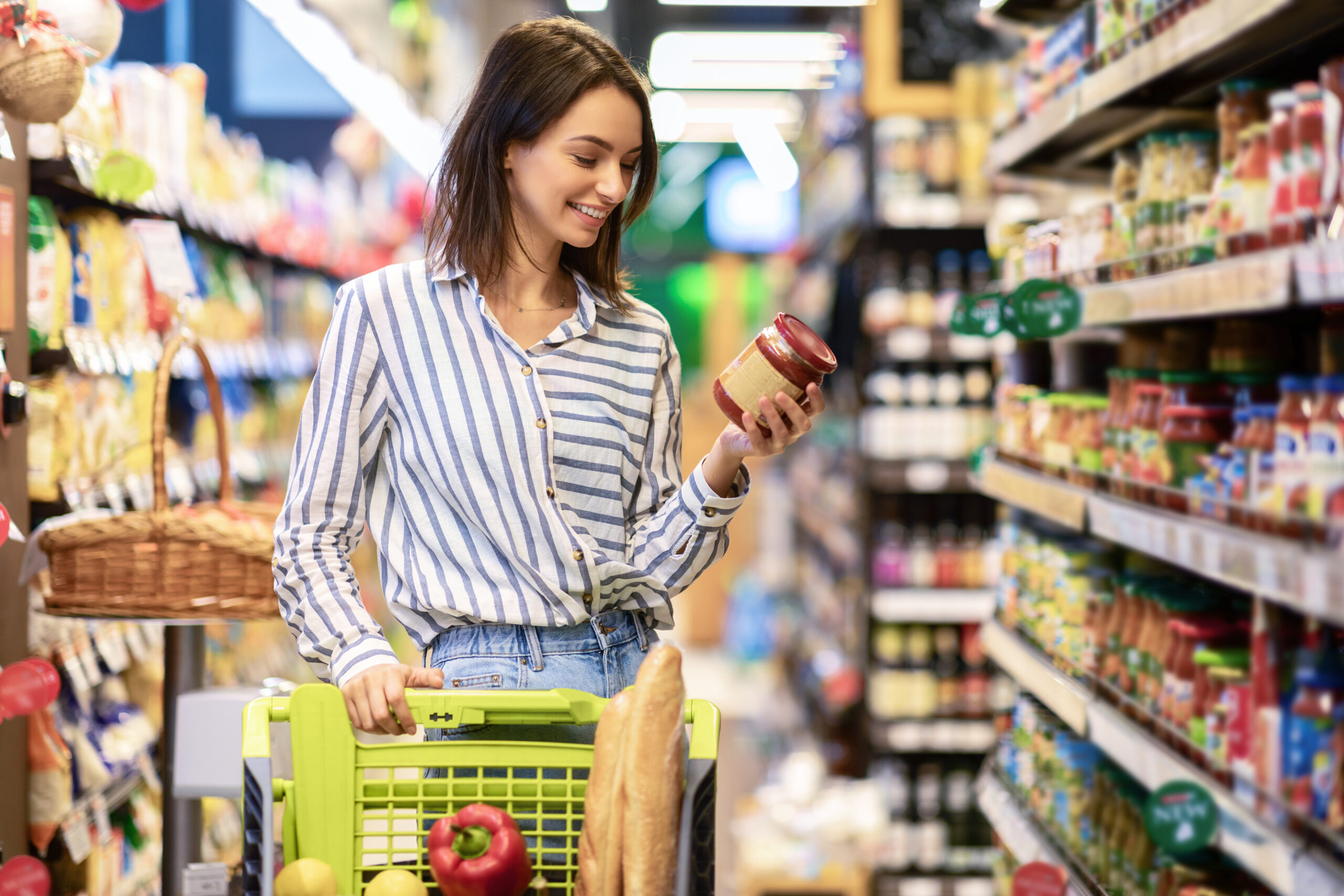Une femme fait ses courses dans un supermarchés. Elle utilise des titres-restaurant pour payer.